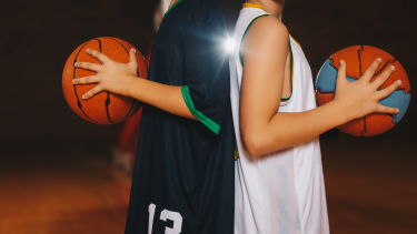 Youth back to back hold basketballs