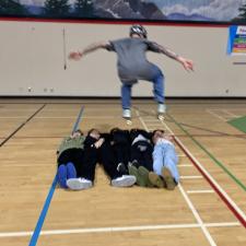 Dave Jonsson ollying over 5 students