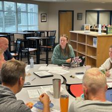 Staff gathered around a table in the library