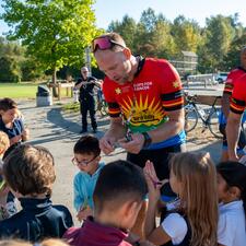 Tour de Valley riders handing out gifts of appreciation to students.